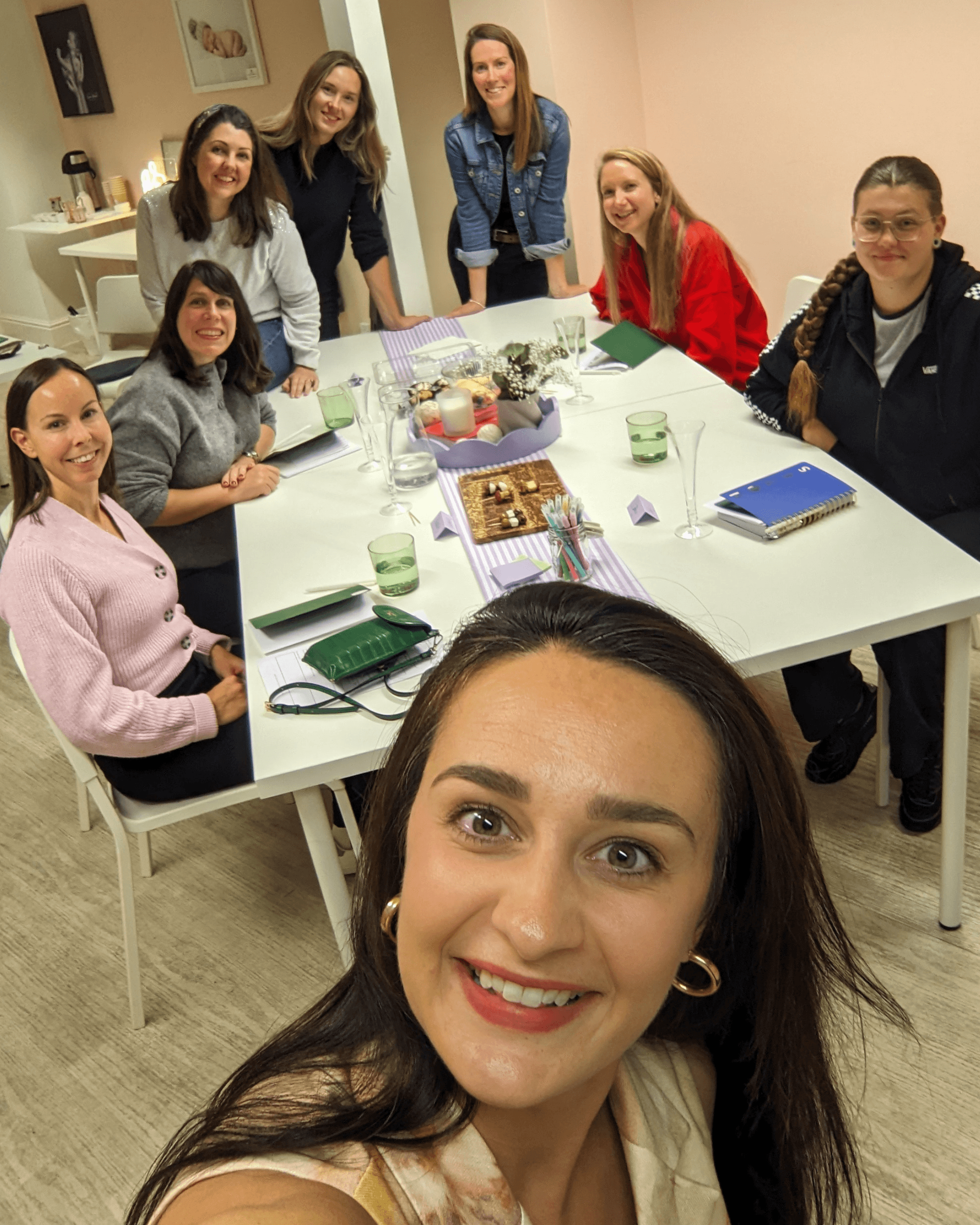 Group of women around a table taking a selfie